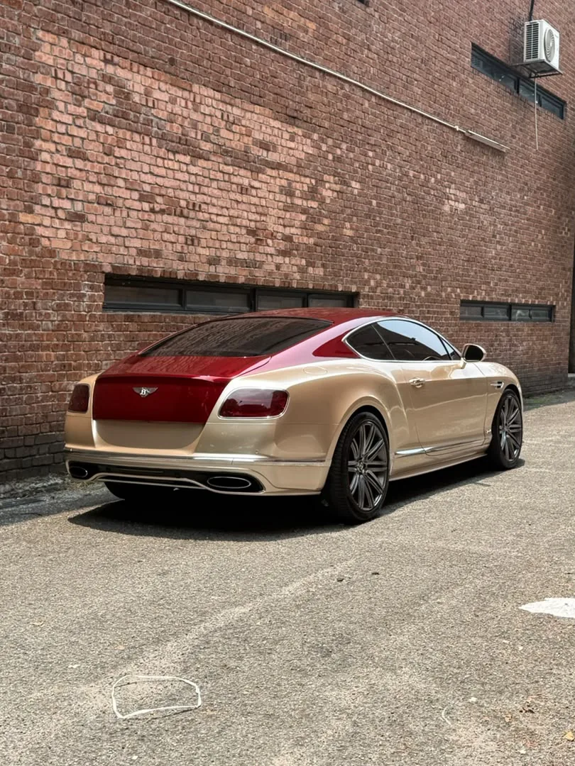 Rear angle of gold and maroon wrap on a Bentley Continental GT by Z-Sticker
